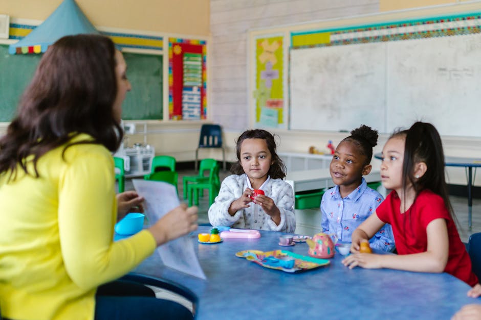 Three diverse young girls engage with a teacher in a vibrant classroom environment
